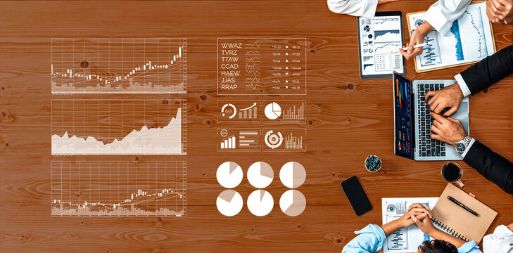 Business professionals engage in data analysis, reviewing financial charts and documents on a wooden table in an office setting, fostering effective teamwork. Axiom