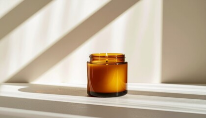 Minimal amber candle jar with geometric sunlight shadow play on clean wall