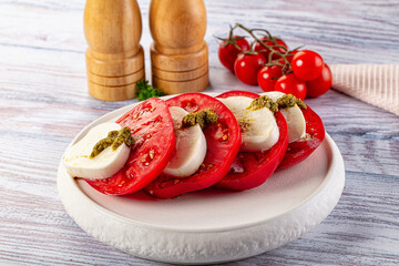 Italian Caprese salad with tomato, mozarella and pesto