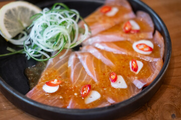 Sliced salmon with spicy sauce served on plate