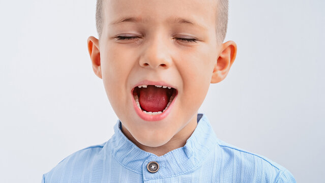 The happy child laughs, showing the gap from the missing baby tooth. - Powered by Adobe