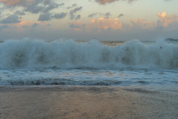 Beautiful sunset over the ocean with dramatic clouds and  wave.
