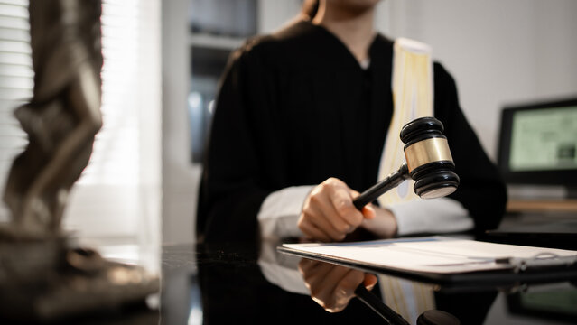 A judge raises gavel in courtroom, poised to deliver formal ruling, global justice, international law, digital regulation, modern legal authority across criminal, trade, cyber, humanitarian fields.