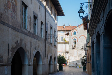 Esterno giorno di tipico paese italiano. Centro storico con strada e case antiche.
