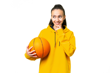 Young Arabian woman playing basketball over isolated wall  over isolated chroma key background looking to the side and smiling