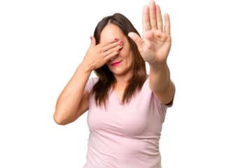 Middle-aged caucasian woman over isolated background making stop gesture and covering face