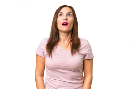 Middle-aged caucasian woman over isolated background looking up and with surprised expression - Powered by Adobe