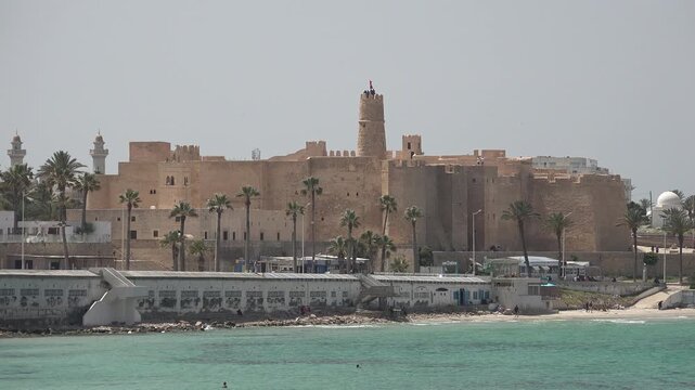 MONASTIR, TUNISIA - JUNE 8th, 2023: Establishing shot of impressive Ribat of Monastir, an historic Islamic defensive structure located on the Mediterranean coastline in Tunisia
