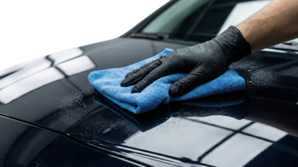 Precision Polish: A gloved hand meticulously wipes a sleek, polished car surface, showcasing a focus on detail and maintenance.