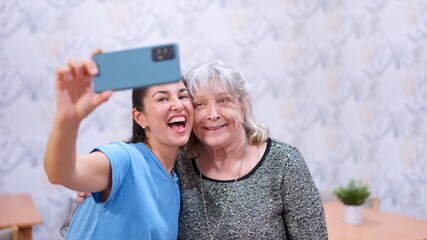 Granddaughter and grandmother happy taking selfie at nursing home