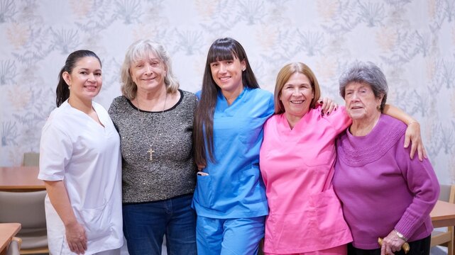 Nursing home staff and senior women smiling together