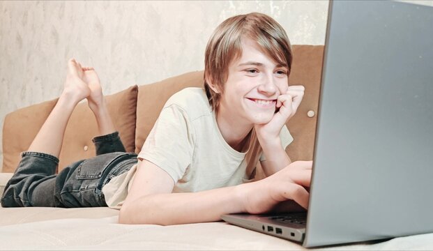 Caucasian teenage boy using laptop, depicting focus and modern indoor lifestyle. Teen focused laptop - Powered by Adobe