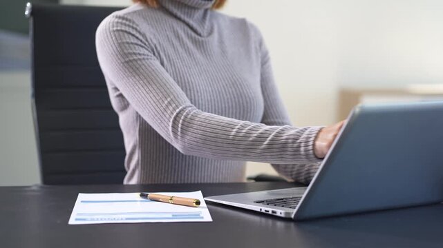 Business woman working on laptop and accounting financial report, accountant using calculator to calculate tax refund at office