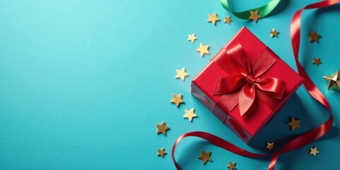 A Festive Red Gift Box with a Satin Bow and Golden Stars on a Teal Background