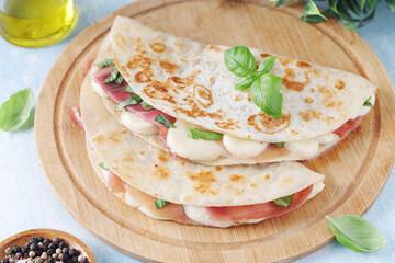 Traditional Italian dish Piadina romagnola - flat bread with mozarella and proscuitto	