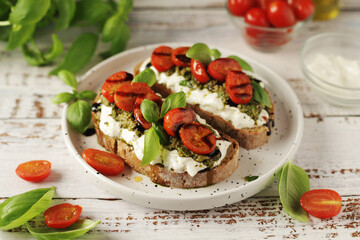 Italian sandwiches with grilled tomatoes, burrata cheese and pesto	
