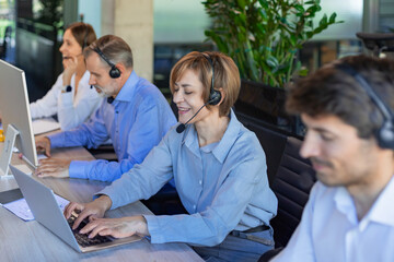 Portrait of happy smiling female customer support phone operator at workplace.