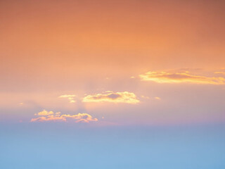 Naklejka premium Soft pastel sunset sky with scattered orange clouds