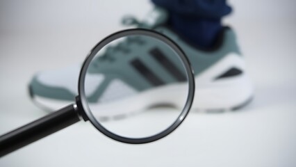 aglet. Magnifying glass focusing on shoe aglet tip with blurred background. lifestyle magazines, social media lookbooks, designed for lifestyle magazines and social media content.