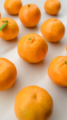 Fresh tangerines scattered on a light surface with soft natural light, highlighting vibrant color and texture. Ideal for food blogs, wellness themes, and citrus product marketing
