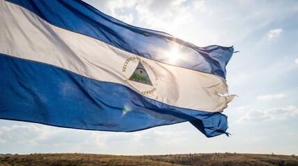 A striking Nicaraguan flag waves proudly against a clear blue sky, suitable for patriotic themes or educational materials.
