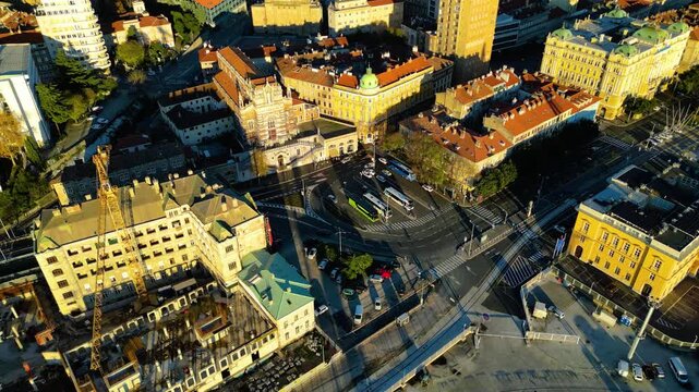 Aerial view of Rijeka, Croatia, showcasing its vibrant port, historic architecture, and ongoing urban development under warm afternoon light.