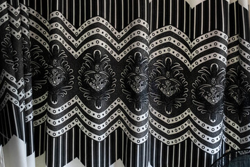 Monochrome close-up of a curtain with intricate patterns.