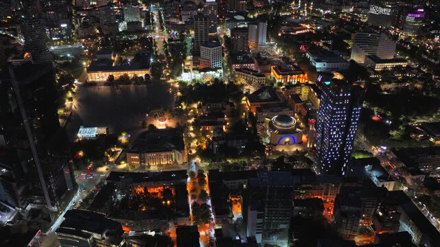 Night aerial video of Tirana showcasing urban streets glowing city lights. 