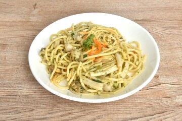 spicy stir fried spaghetti with scallop in garlic butter sauce topping shrimp egg on plate 