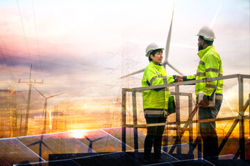 Two engineers in high-visibility vests shaking hands on an elevated platform, overseeing solar...