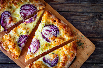 Pinsa bianca white pizza with red onion and oregano on wooden table. Top view