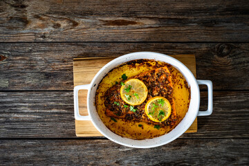 Obraz premium Baked salmon fillet on wooden table. Top view