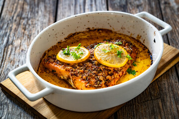 Baked salmon fillet on wooden table