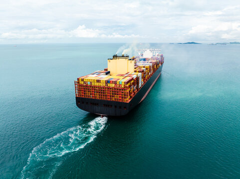 Aerial back view of large cargo container ship sailing in sea for global business logistics and international import export trade transportation industry.