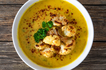 Cauliflower cream soup on wooden table. Top view