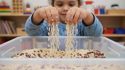 Child with Sensory Differences Engaging in Tactile Play with Rice