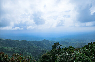 Lush green hills and valleys under a vast cloudy sky with horizon