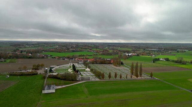Aerial screenshot showing Tyne Cot Cemetery with a flock of birds flying above the landscape in Flanders, near historic WWI battlefields of Ypres.
