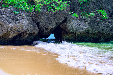  波が寄せる岩の間から青い海を望む石垣島の美しい風景