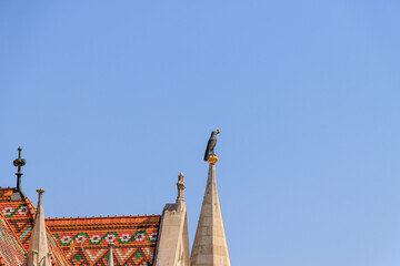 Budapest, Hungary. The raven with a gold ring in its bill sitting on top of a spire of the Church of King Mathias.