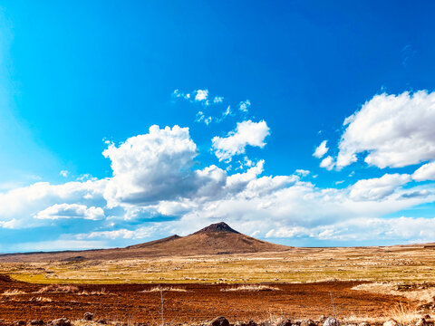 white clouds on the blue sky  beige mountins in spring
