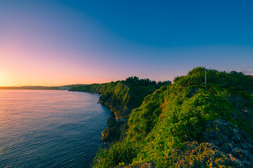  真栄田岬の断崖に朝日が差し込む美しい沖縄の海岸線