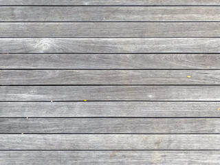 Obraz premium Horizontal close-up texture of a deck floor made of aged wooden planks with faded gray color and natural grain details.