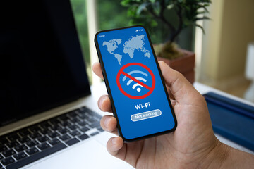 man hand holds phone with Wi-Fi banned on screen cafe