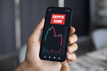 man hand hold phone with chart scam crypto coins screen