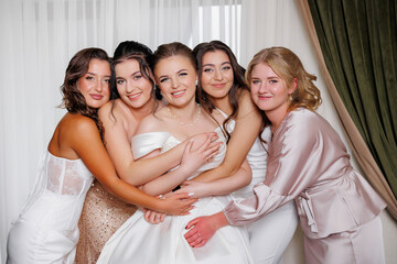 Bridesmaids and bride share joyful moment together before wedding ceremony