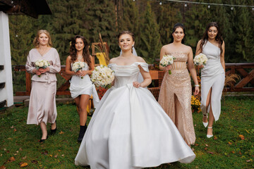 Elegant bridal party walks through a scenic garden during a wedding celebration in autumn