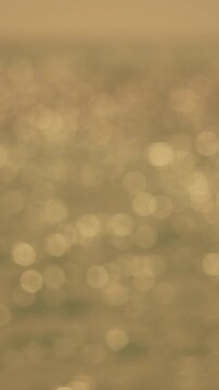 Water Sunlight Bokeh: Abstract blurry image showing sunlight reflecting on water surface, likely outdoors, daytime, for aesthetic purposes.