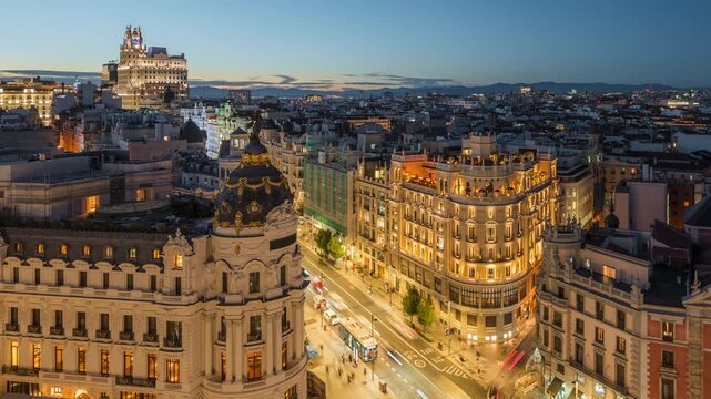 Dusk to night timelapse of historic buildings and rush hour traffic on Gran Via street in Madrid, Spain.