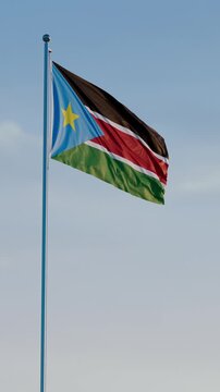 South Sudan, Juba: Cinematic Vertical Waving National Flag Against Blue Sky